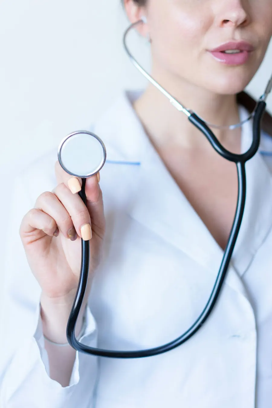 Médica de jaleco branco com estetoscópio