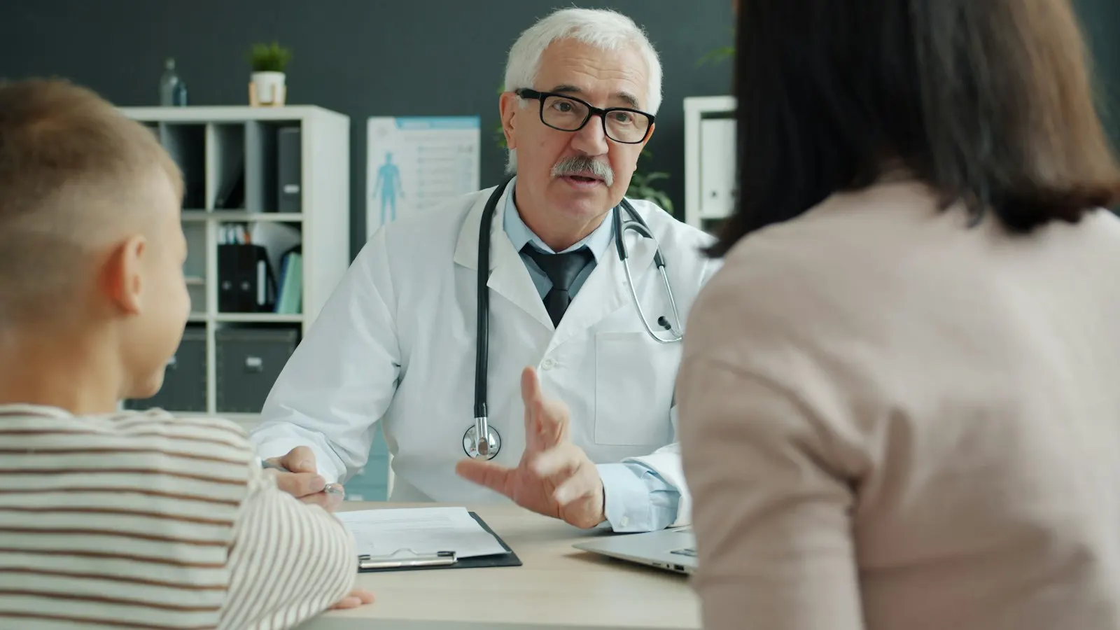 Médica atendendo mãe e criança no consultório