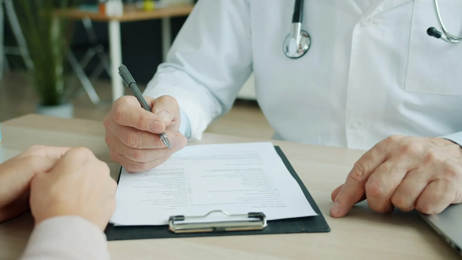 Médico anotando informações no prontuário do paciente
