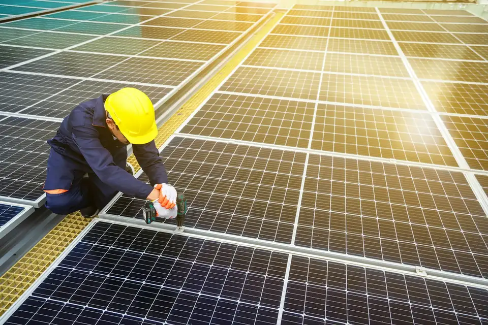 Técnico de capacete trabalhando em painel solar